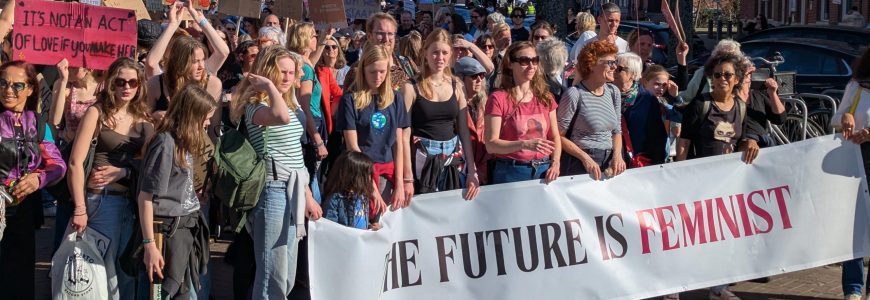 vrouwen marsen met een “the future is feminist” banner